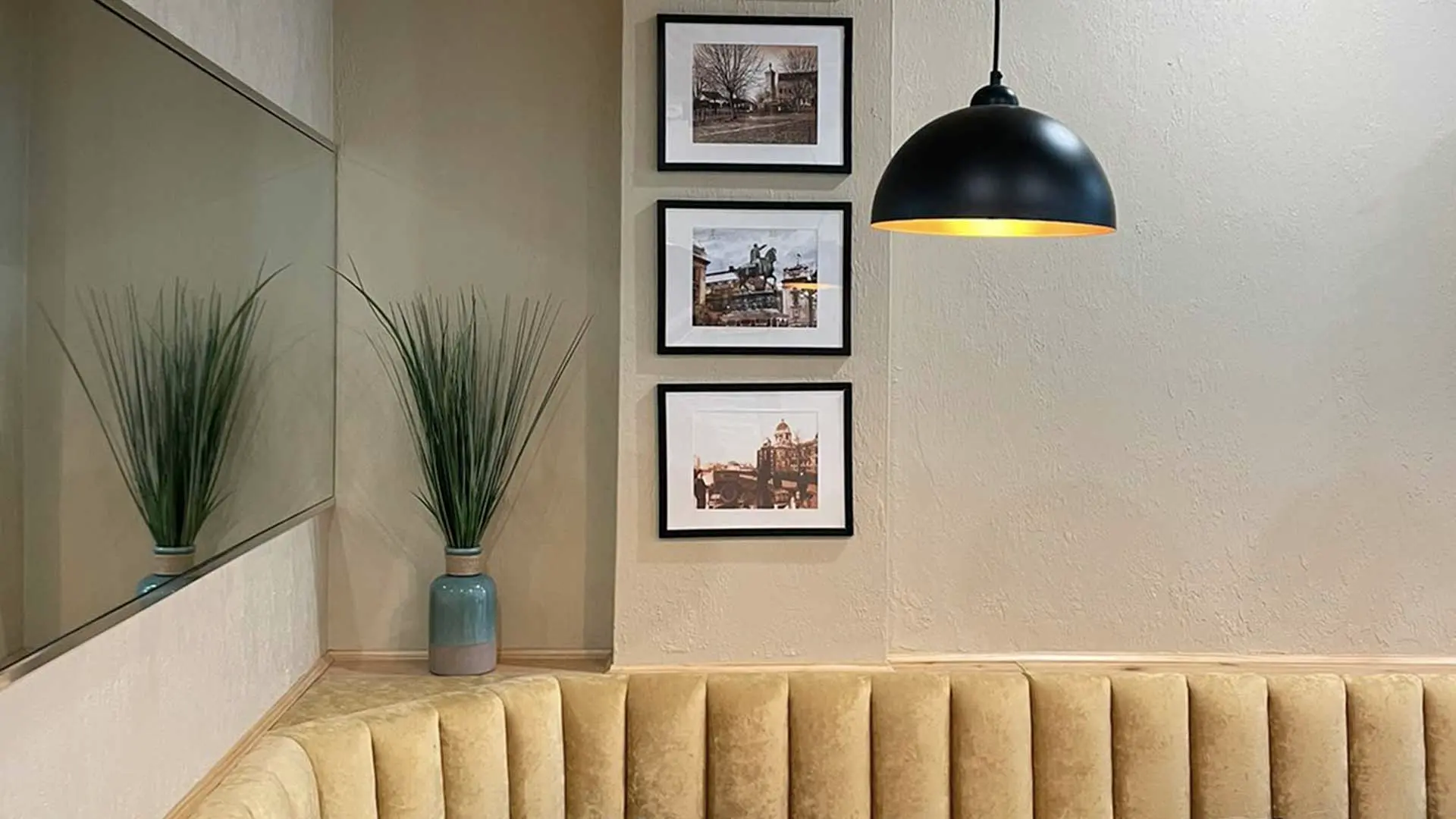 Yellow banquette seating, plants and framed wall photographs