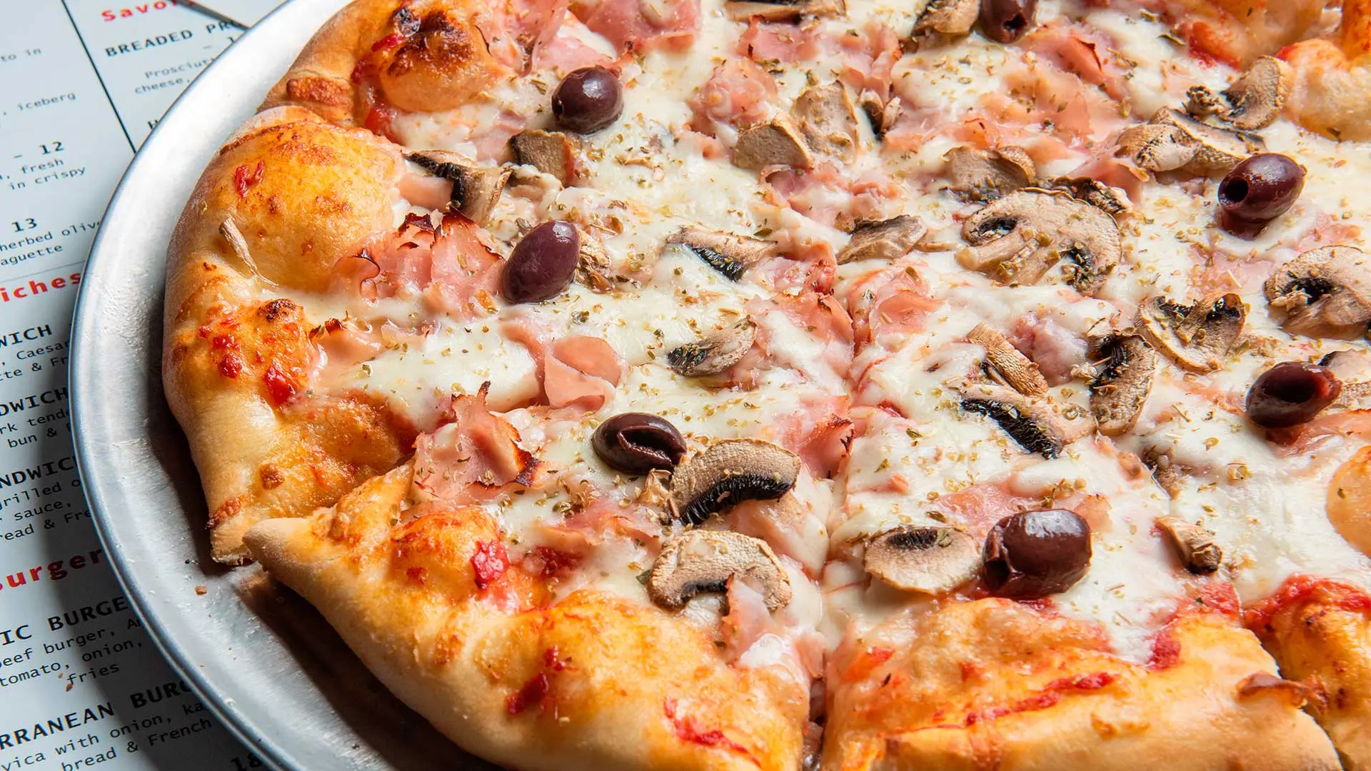 Capricciosa pizza with ham and mushrooms